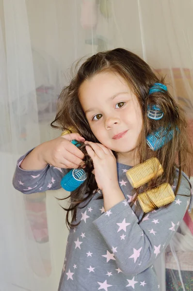 Girl smiles with curlers in hair — Stock Photo, Image