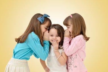 Cute young sisters sharing a surprising secret, isolated on whit clipart