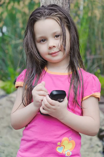 Kleines Mädchen, das mit einem Handy spricht — Stockfoto