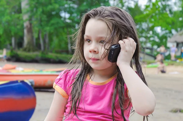 Klein meisje in gesprek met een mobiele telefoon — Stockfoto