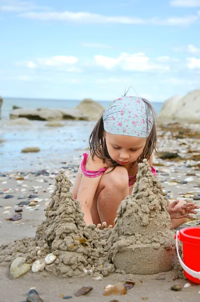 Chica construcción de castillos de arena en la playa —  Fotos de Stock