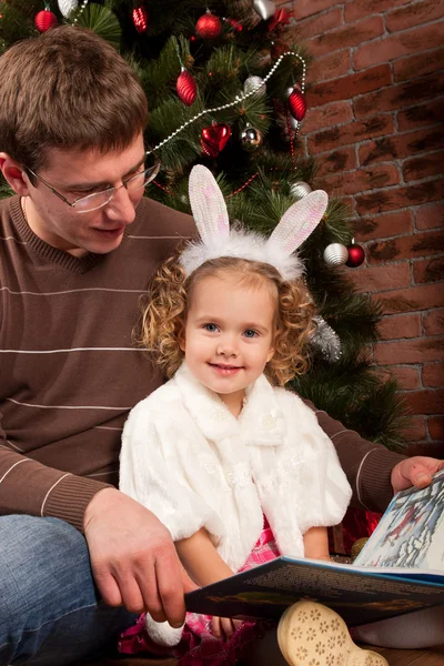Meisje met haar vader in de buurt van de kerstboom — Stockfoto