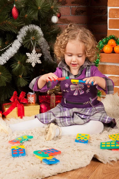 Little girl play near Christmas tree — Stock Photo, Image