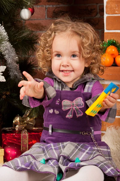 Μικρό κορίτσι παιχνίδι κοντά χριστουγεννιάτικο δέντρο — Φωτογραφία Αρχείου