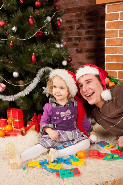 Menina brincar com o pai perto da árvore de Natal — Fotografia de Stock