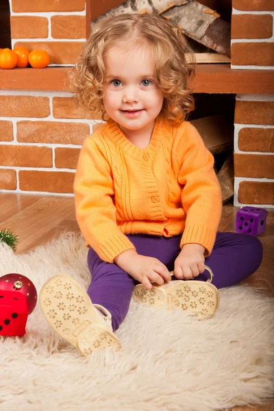 Little girl sitting near fireplace — Stock Photo, Image