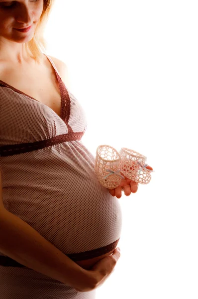 Hamile kadınla bebek patik, eller üzerinde odak — Stok fotoğraf