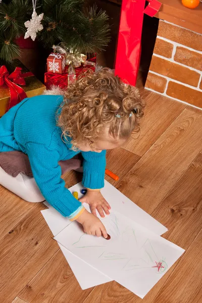 Маленькая девочка рисует рядом с елкой — стоковое фото