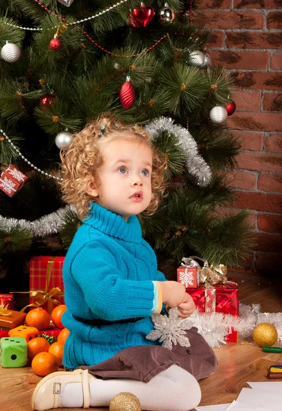 Маленькая девочка рядом с елкой — стоковое фото