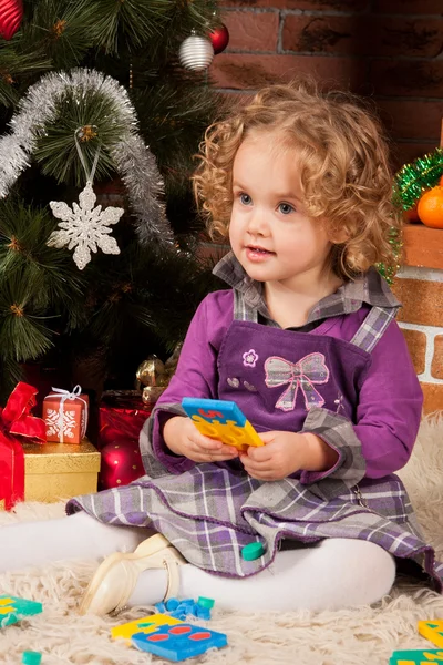 Klein meisje spelen in de buurt van de kerstboom — Stockfoto