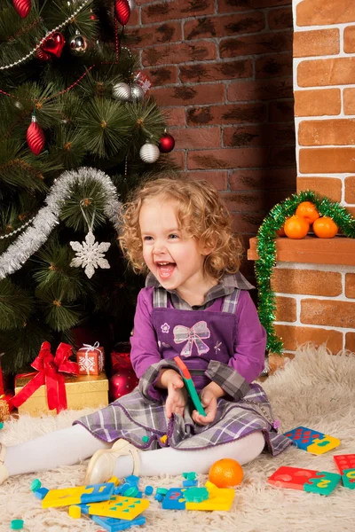 Noel ağacı yakınındaki küçük kız oyun — Stok fotoğraf