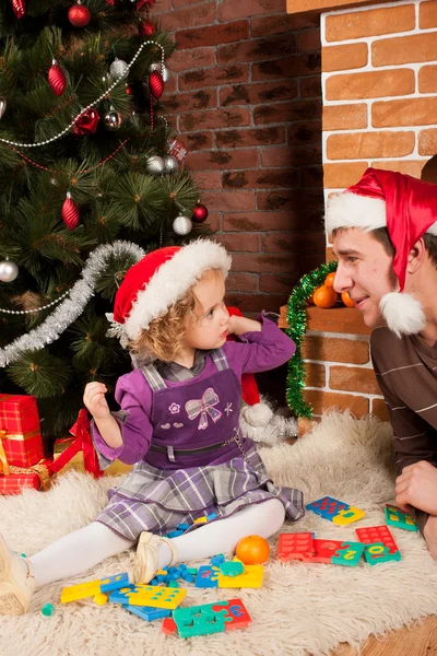 クリスマスの木の近くのお父さんと遊ぶ少女 — ストック写真