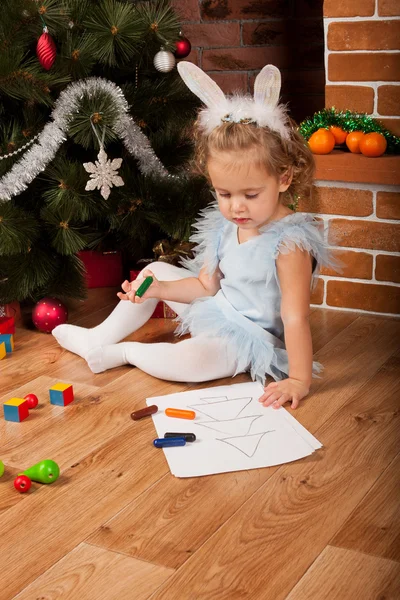 Menina desenho perto da árvore de Natal — Fotografia de Stock