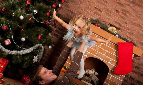 Klein meisje spelen met papa in de buurt van de kerstboom — Stockfoto