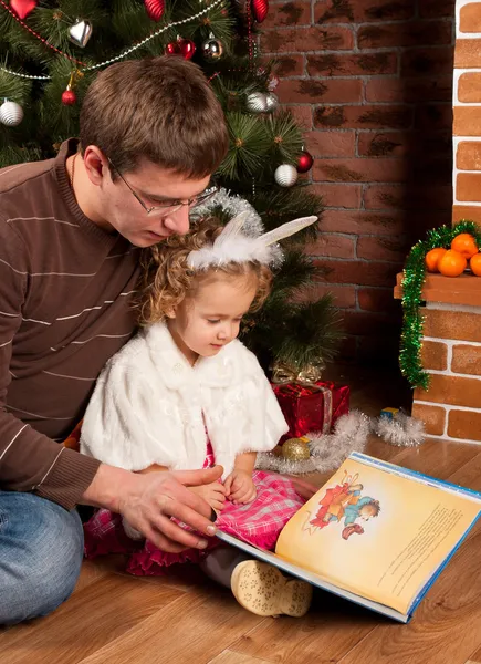 Liten flicka med sin pappa nära julgran — Stockfoto