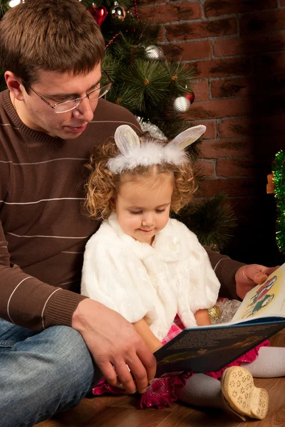 Meisje met haar vader in de buurt van de kerstboom — Stockfoto