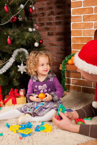 Küçük kız oyun ile baba Noel ağacının yakınında — Stok fotoğraf