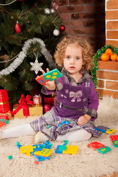 Liten flicka spela nära julgran — Stockfoto