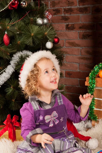 Liten flicka spela nära julgran — Stockfoto
