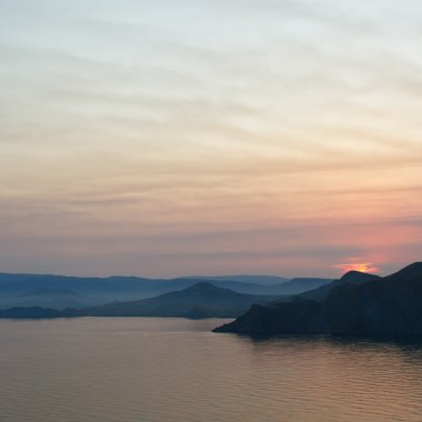 dağlar ve deniz üzerinde renkli düşüş.