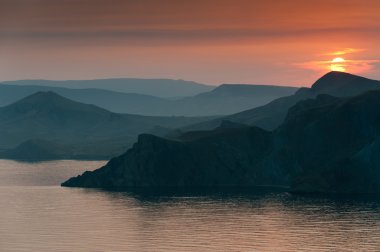 dağlar ve deniz üzerinde renkli düşüş.