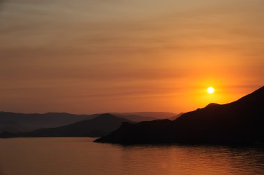 dağlar ve deniz üzerinde renkli düşüş.