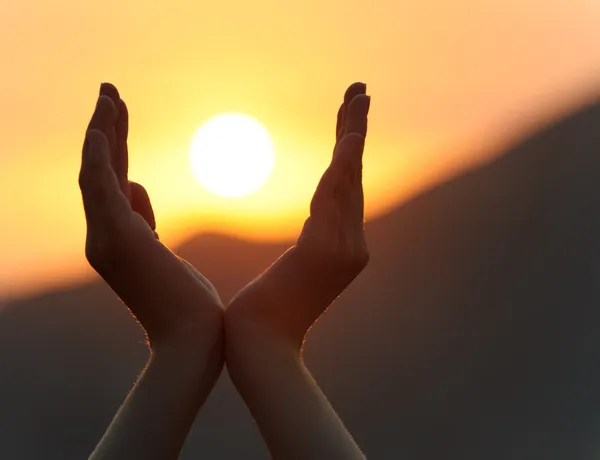 Solnedgång i händerna — Stockfoto