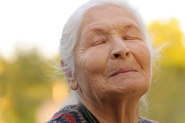 De oudere vrouw met gesloten ogen — Stockfoto