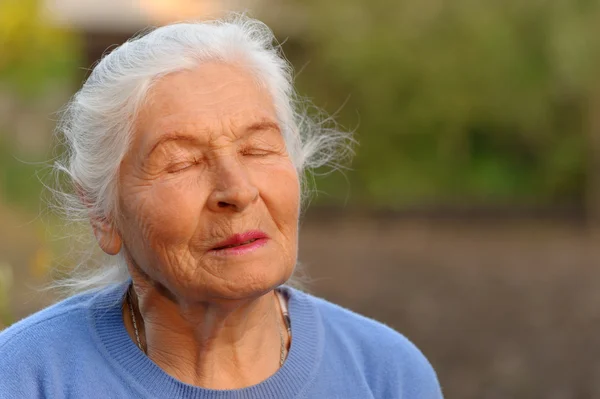 Starsza kobieta z zamkniętymi oczami — Zdjęcie stockowe