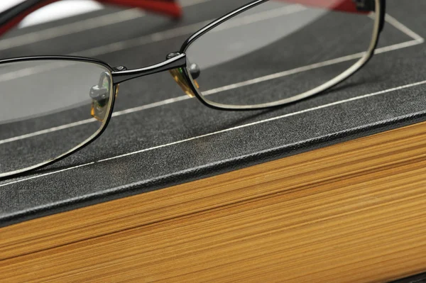 Gafas graduadas en el viejo libro grueso — Foto de Stock