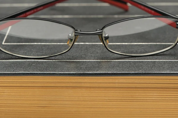 Glasögon på gamla tjocka boken — Stockfoto