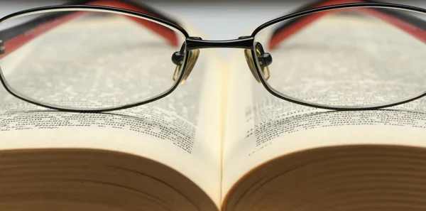 Bril op het oude opren boek — Stockfoto