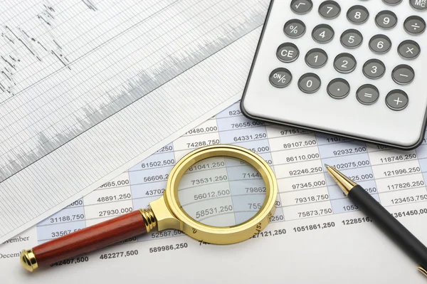 A calculadora, a lupa e o relatório financeiro — Fotografia de Stock