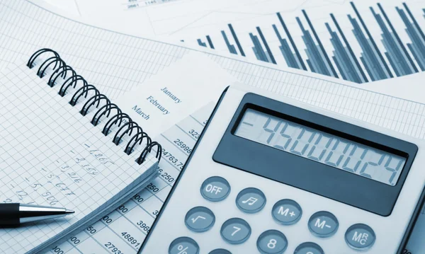 La calculadora y el informe financiero tonificado azul — Foto de Stock