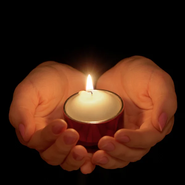 Hořící svíčka v ženských rukou — Stock fotografie