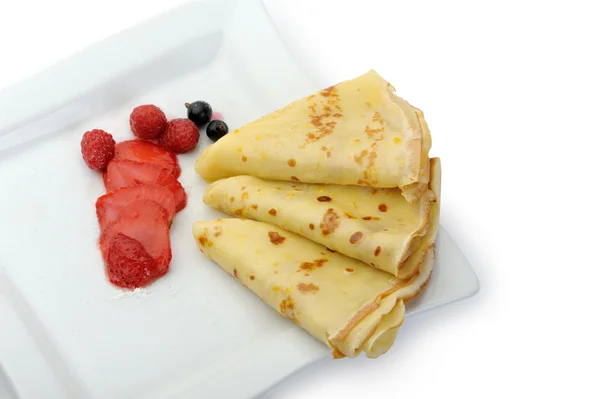 Crepe on a plate with a strawberry, a raspberry and a bilberry — Stock Photo, Image