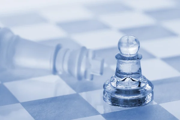 Glass chess. A victory of a pawn over a king — Stock Photo, Image