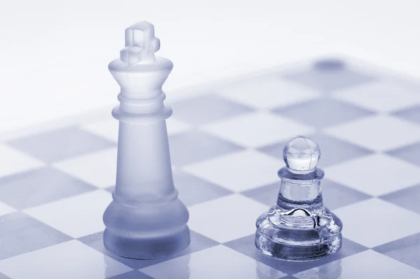 Skleněné šachy. pěšec a král — Stock fotografie