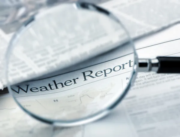 Loep ligt op de krant met titel weather report. blauwe Toon — Stockfoto