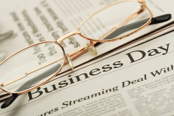 stock image Eyeglasses lie on the newspaper with title Business day