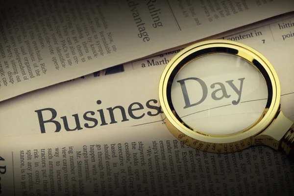 stock image Loupe lies on the newspaper with title Business day.Selective li