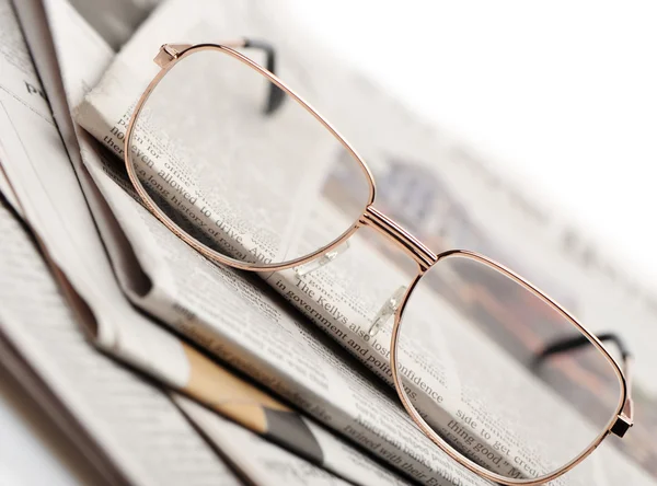 Os óculos estão em uma pilha de jornais — Fotografia de Stock