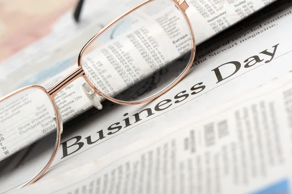 stock image Eyeglasses lie on the newspaper with title Business day