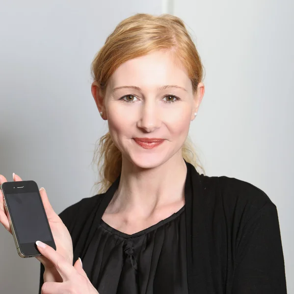 Jovem, mulher sorridente apresentou seu smartphone — Fotografia de Stock