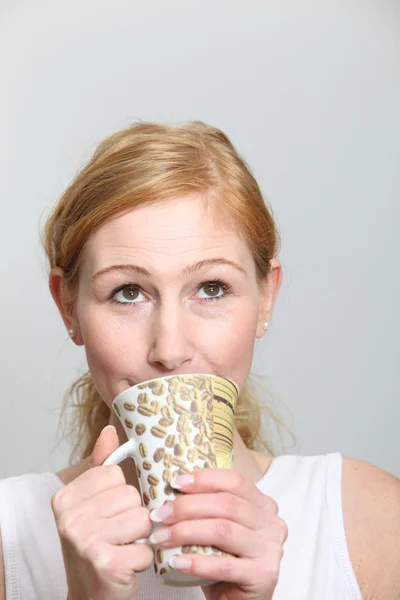Jovem mulher gosta de seu café e olha para cima — Fotografia de Stock