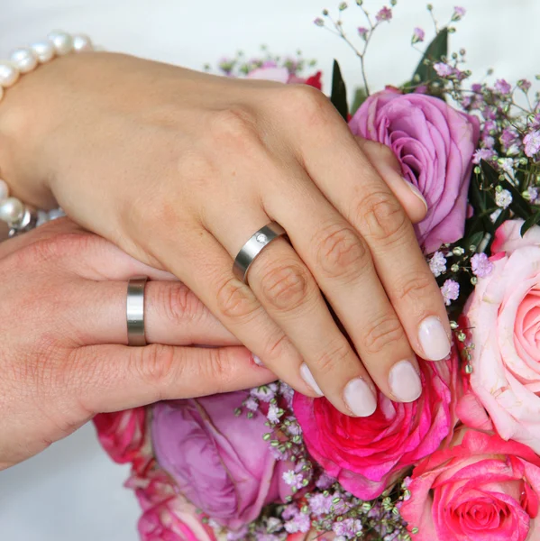 Mani di una sposa e sposo con fedi nuziali — Foto Stock