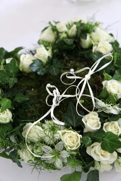 Anillos de boda en un corazón de rosas blancas —  Fotos de Stock