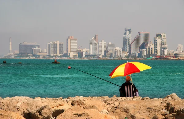 Rybář sedí na dělení vlny Středozemního moře. — Stock fotografie