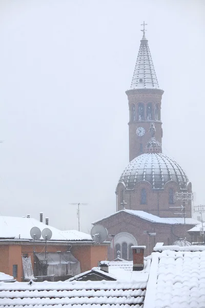 Kirche und Dächer unter dem Schnee. — Stockfoto