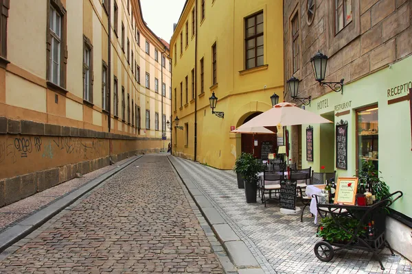 Alte Straße mit kleinem Hotel und Restaurant im Freien in Prag. — Stockfoto